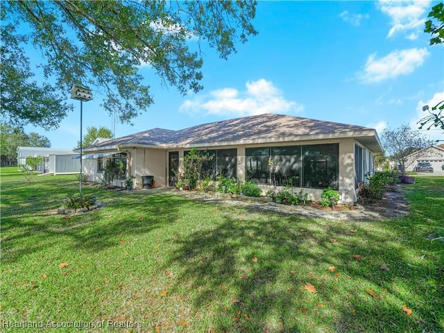 back of property featuring a sunroom and a lawn