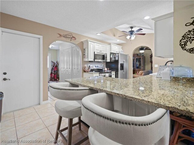 112 Eventide Ave, Lake Placid, FL 33852 - kitchen featuring appliances with stainless steel finishes, arched walkways, ceiling fan, a kitchen breakfast bar, and recessed lighting