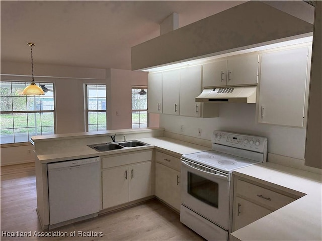 kitchen featuring under cabinet range hood, a sink, white appliances, a peninsula, and light countertops