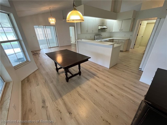 kitchen featuring high vaulted ceiling, light wood finished floors, under cabinet range hood, and white range with electric cooktop