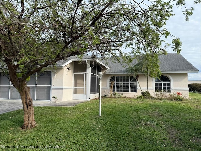 view of front of home with a front lawn, an attached garage, driveway, and stucco siding