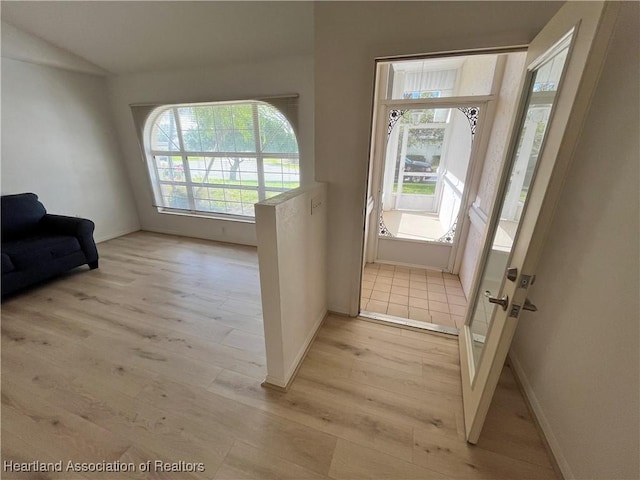 doorway to outside with light wood-style floors and baseboards