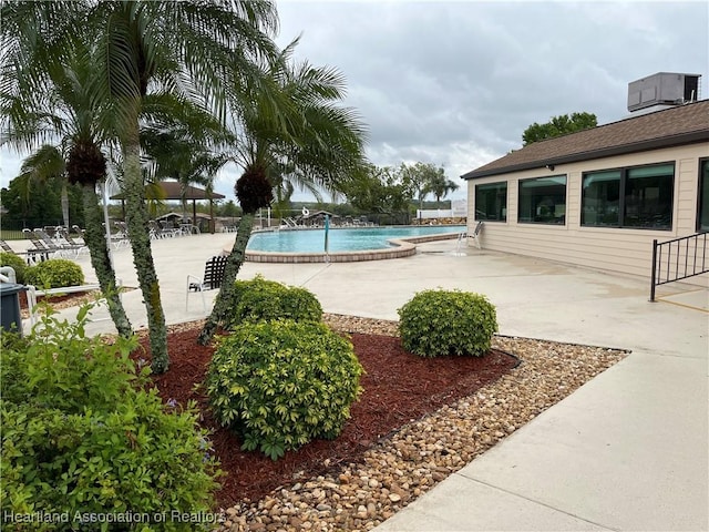 community pool featuring central AC unit and a patio area