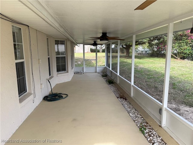 unfurnished sunroom featuring a ceiling fan