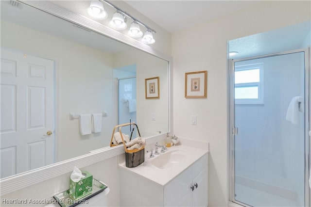 bathroom with a shower stall and vanity