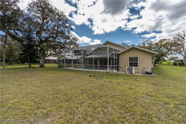 back of property featuring a lanai, stucco siding, an outdoor pool, and a lawn