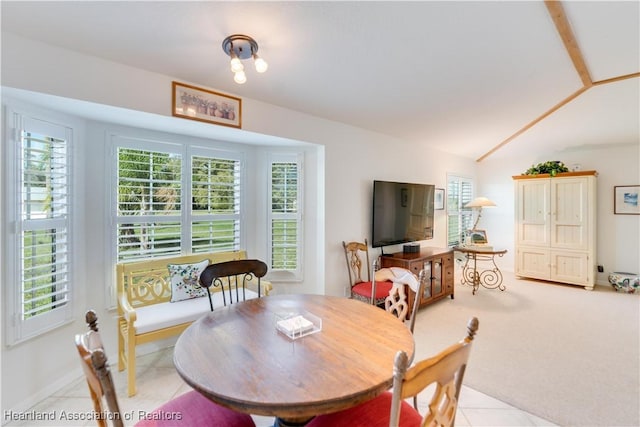 dining space with light carpet and vaulted ceiling