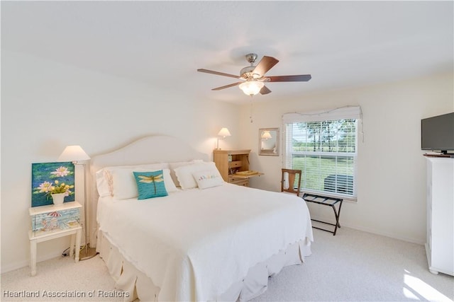 bedroom featuring light carpet, a ceiling fan, and baseboards