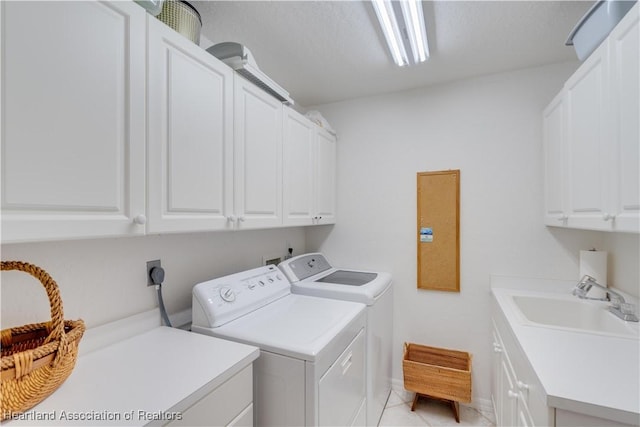 laundry area featuring light tile patterned floors, independent washer and dryer, a sink, and cabinet space