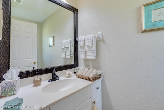 bathroom featuring vanity and a textured wall