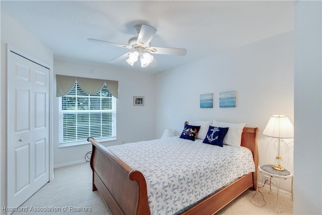 bedroom featuring a closet, light carpet, ceiling fan, and baseboards