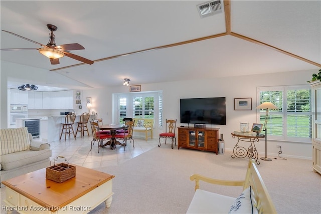 living area featuring light carpet, light tile patterned floors, visible vents, lofted ceiling, and wine cooler