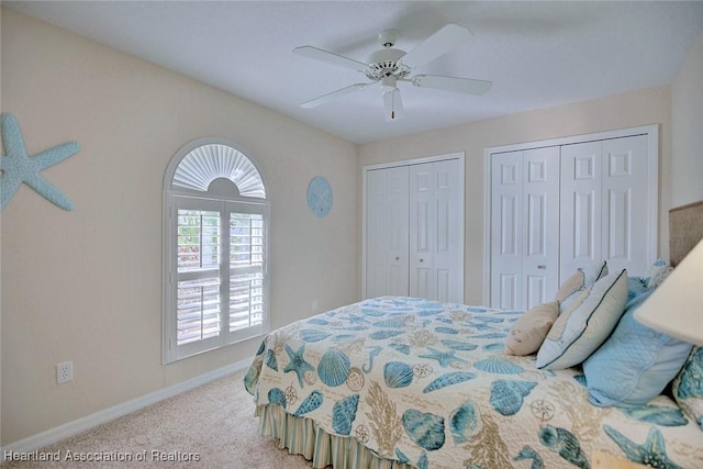 bedroom with two closets, light colored carpet, and ceiling fan