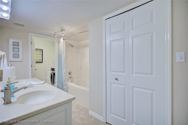 bathroom with shower / bathtub combination with curtain, vanity, and a textured ceiling