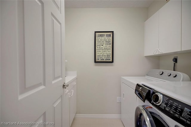 clothes washing area with cabinets and washer and dryer