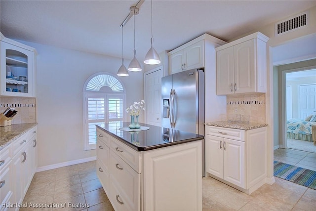 kitchen with white cabinetry, pendant lighting, stainless steel fridge, and decorative backsplash