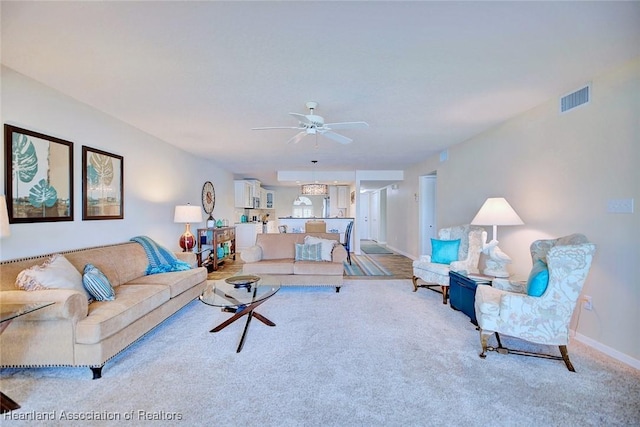 carpeted living room with ceiling fan