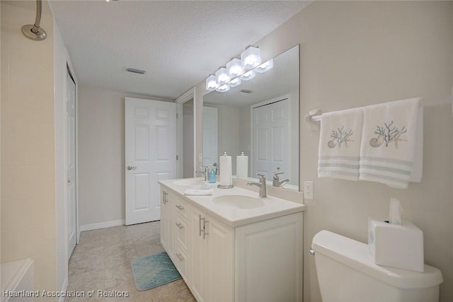 bathroom featuring vanity, toilet, and a textured ceiling