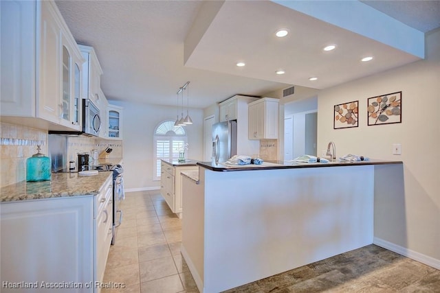 kitchen featuring decorative light fixtures, tasteful backsplash, white cabinets, kitchen peninsula, and stainless steel appliances