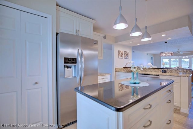 kitchen with stainless steel refrigerator with ice dispenser, white cabinetry, a center island, hanging light fixtures, and kitchen peninsula