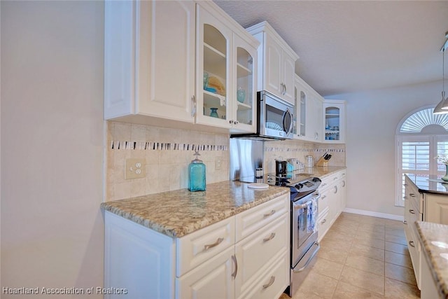 kitchen featuring white cabinetry, light stone countertops, tasteful backsplash, and stainless steel appliances