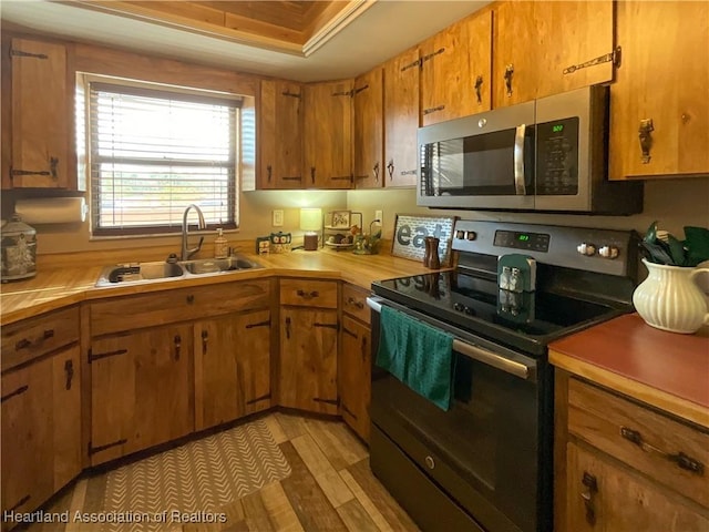 kitchen with sink, range with electric cooktop, and a raised ceiling