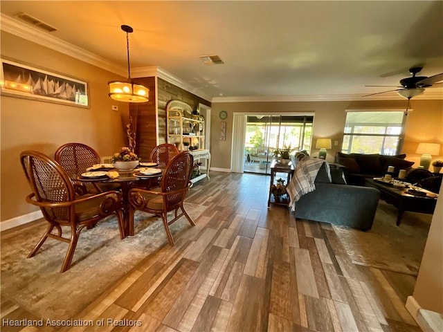 dining space with ceiling fan, hardwood / wood-style floors, and crown molding