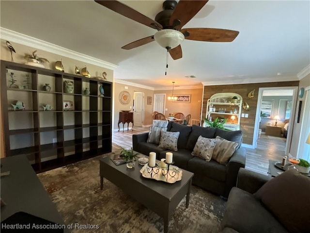 living room featuring ceiling fan, crown molding, and wood-type flooring