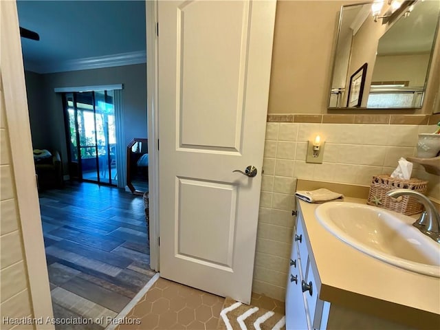 bathroom featuring tile walls, crown molding, and vanity