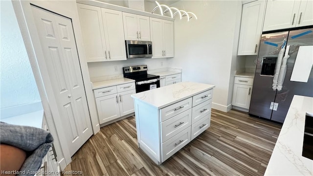 kitchen featuring white cabinets, appliances with stainless steel finishes, dark hardwood / wood-style floors, and light stone countertops