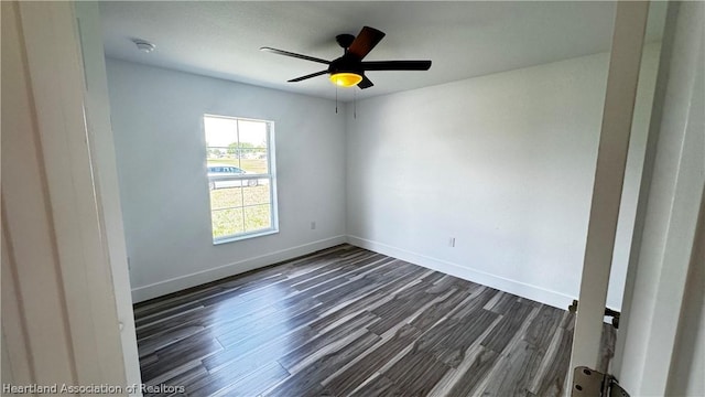 spare room with dark hardwood / wood-style floors and ceiling fan