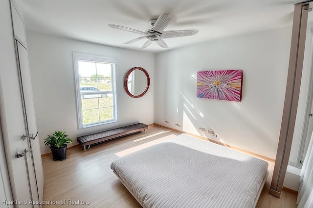 bedroom featuring ceiling fan, light hardwood / wood-style floors, and a closet