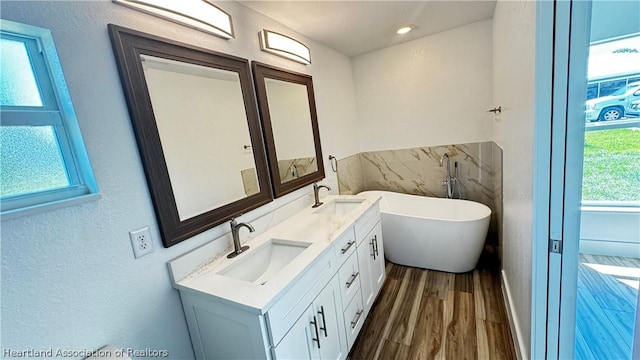 bathroom featuring a bath, vanity, plenty of natural light, and hardwood / wood-style floors