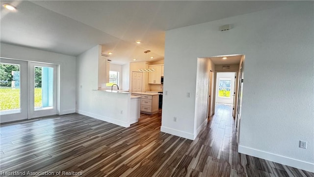 unfurnished living room featuring dark hardwood / wood-style flooring and vaulted ceiling