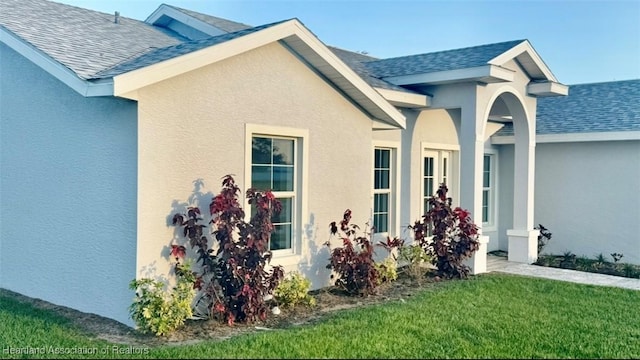 1015 Duane Palmer Blvd, Sebring, FL 33876 - entrance to property with a shingled roof, stucco siding, and a yard