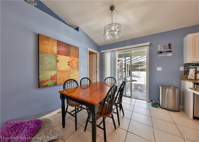 dining room with lofted ceiling, an inviting chandelier, and light tile patterned floors