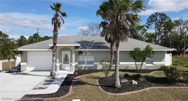 single story home with a garage, concrete driveway, a shingled roof, and stucco siding