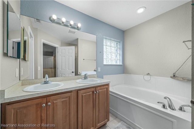 full bathroom with visible vents, double vanity, a sink, and a bath