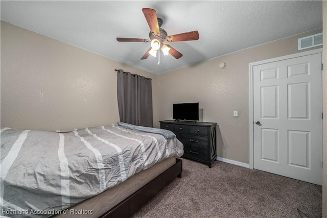 carpeted bedroom featuring ceiling fan, a textured ceiling, visible vents, and baseboards