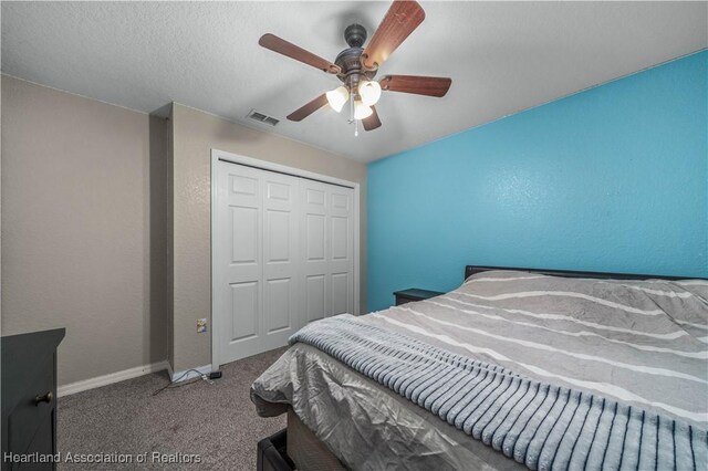 carpeted bedroom with a textured ceiling, a ceiling fan, visible vents, baseboards, and a closet