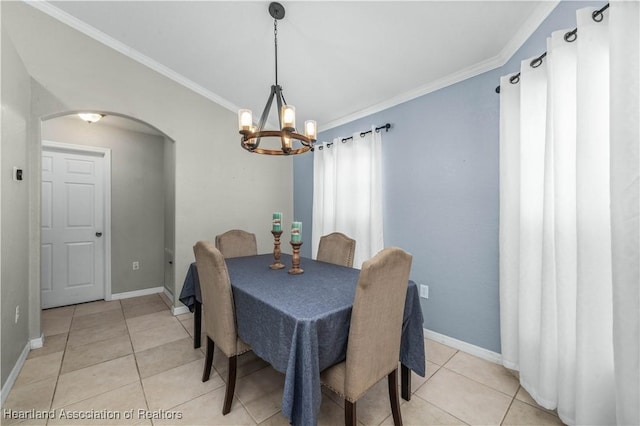 dining area featuring light tile patterned floors, baseboards, arched walkways, and crown molding