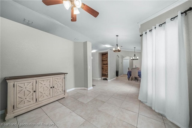 corridor featuring light tile patterned floors, baseboards, visible vents, arched walkways, and vaulted ceiling