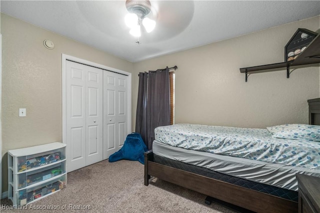 bedroom featuring carpet, a ceiling fan, a closet, and a textured wall