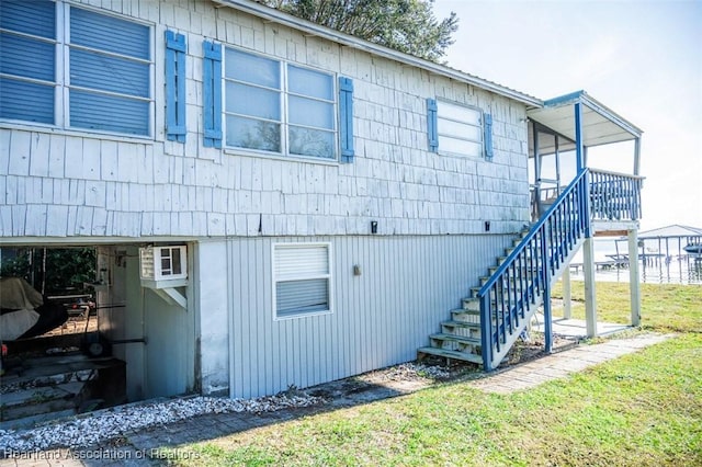 view of property exterior with a yard and stairs