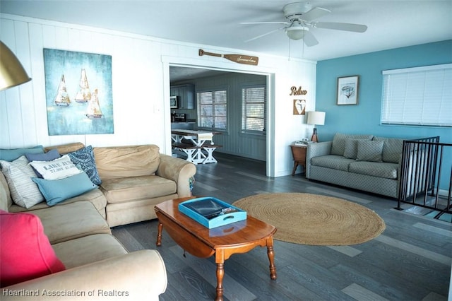 living area featuring ceiling fan and dark wood-style flooring