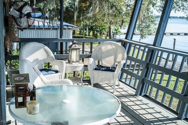 balcony with outdoor dining area and a deck with water view