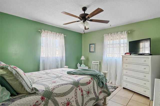 tiled bedroom featuring ceiling fan and a textured ceiling