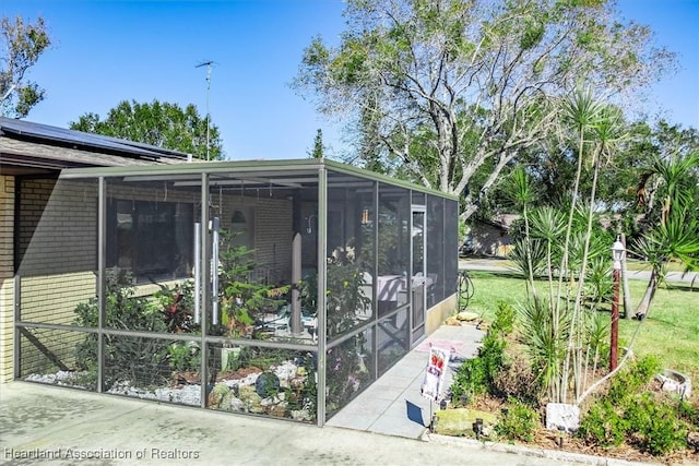 view of side of home with a sunroom and a yard