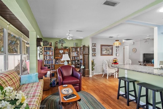 living room with ceiling fan and light hardwood / wood-style flooring