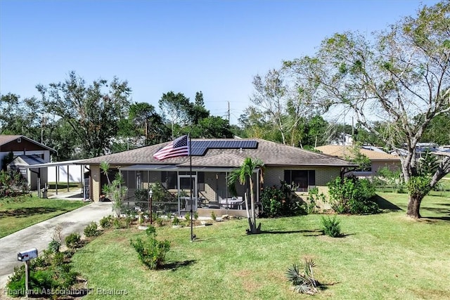 ranch-style home featuring a front lawn, a carport, and a sunroom